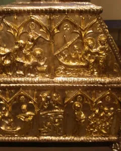 Sant Cugat Casket with a sloped lid, covered in intricate embossed scenes and small figures within arched panels.