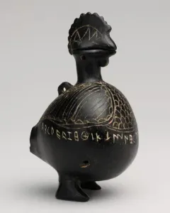 Viterbo Rooster, a dark bird-shaped vessel with etched feather patterns and an inscription around the lower body.