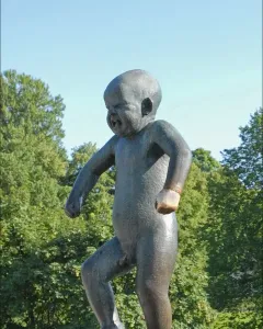 Angry Boy bronze statue of a crying toddler with clenched fists on a pedestal.