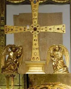 The Cross of the Angels, a jeweled golden cross displayed in a glass case with kneeling angel figures beside it.