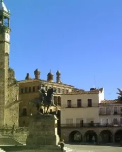 Francisco Pizarro equestrian statue on a stone pedestal in a sunlit square.
