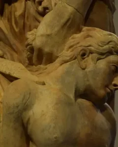 Marble sculpture of The Sacrifice of Isaac showing a raised hand holding a dagger above a bowed, bare-chested figure.