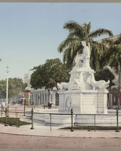 Fuente de la India fountain with a seated female statue and dolphin sculptures in a street median