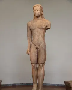 Sounion Kouros marble statue of a nude male youth with long braided hair, shown front-facing with a missing left arm.