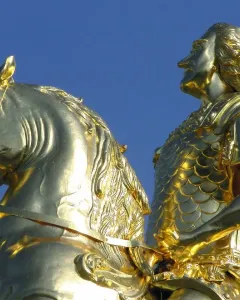 The Golden Rider equestrian statue in Dresden, showing a gilded man on a rearing horse against a blue sky.