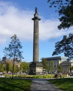 The Melville Monument rising above a green park with people walking along paved paths.