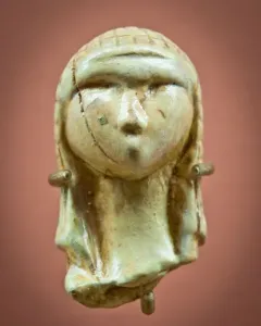 Venus of Brassempouy carved head with a textured cap and cracked surface