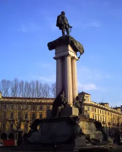 Monument to Vittorio Emanuele II with a bronze statue atop a fluted column and sculpted figures at the base.