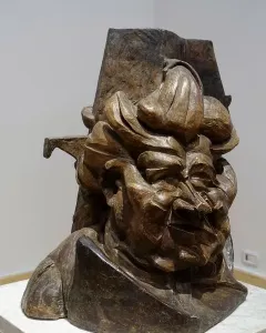 L\'antigrazioso, a bronze-toned abstract bust with angular fragmented forms and a distorted face.