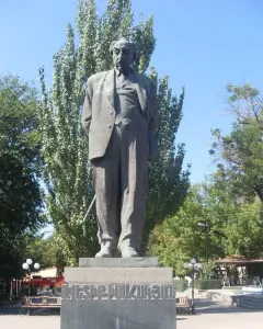 Bronze monument to Avetik Isahakyan on a stone pedestal in a park setting.