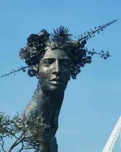 Reminiscencia, a metallic bust with an elongated neck and an ornate crown of metal flowers and spiky foliage.