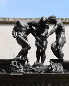 The Three Shades by Rodin, showing three dark bronze nude figures grouped together with bowed heads.