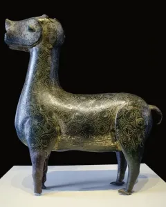 Stylized metallic deer sculpture from Madinat al Zahra on a white pedestal.