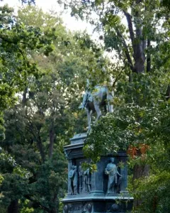 The Major General John A. Logan bronze equestrian statue on a tall pedestal in a park, with trees and buildings in the background.