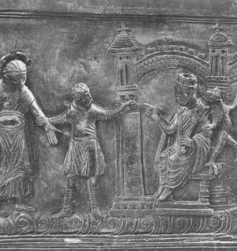 Bronze relief panel from the Bernward Doors showing several figures, a seated crowned ruler, stylized buildings, and a small dragon-like creature.