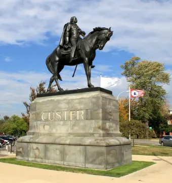Custer equestrian statue on a stone pedestal with CUSTER carved on the front