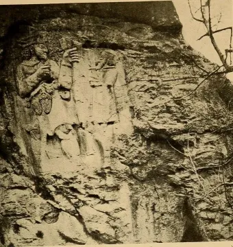 Ivriz relief showing two carved figures on a rock face, one holding a cluster of objects and the other raising an object overhead.