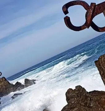 Peine del Viento rusted steel sculptures on coastal rocks with waves and the sea beyond