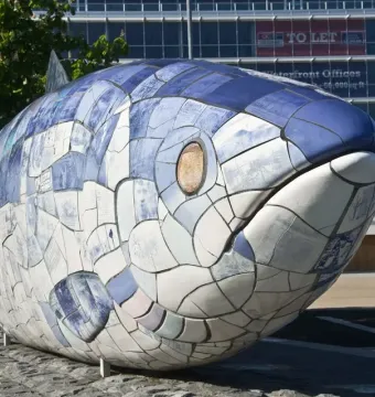 The Big Fish sculpture covered in blue and white ceramic tiles with printed text and images.