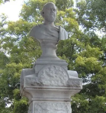 Beriah Magoffin Monument with a bust of a bearded man on a pedestal in a cemetery.