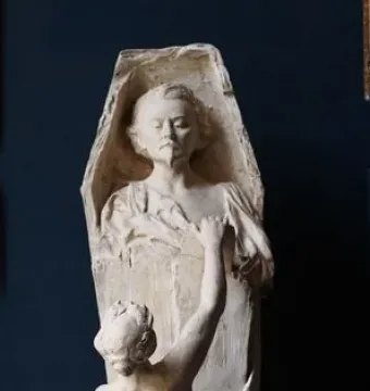 La Gloire sculpture showing a nude female figure reaching upward and pulling apart a tall structure with a man\'s bust at the top.