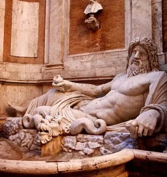 Marforio marble statue of a reclining bearded man in a stone basin