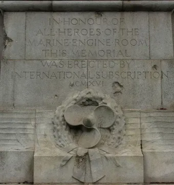 Titanic Engine Room Heroes Memorial stone inscription with carved figures, a ship\'s propeller, wreath, and anchor relief.