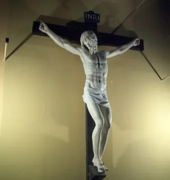 Benvenuto Cellini crucifix showing a white marble Christ figure on a dark wooden cross with INRI at the top.