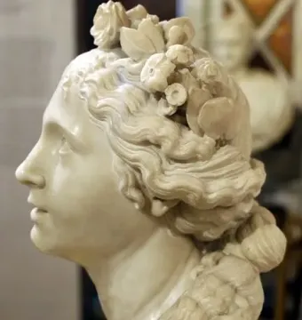 Blessed Soul, a white marble bust of a female figure in profile with wavy hair and a floral wreath.