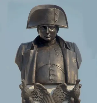 Bronze bust of Napoleon I in a bicorne hat on a plinth with bronze eagles.
