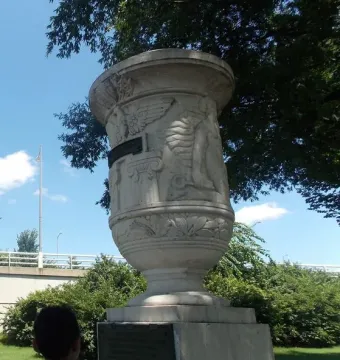 The Cuban Friendship Urn mounted on a pedestal outdoors with a person standing nearby.