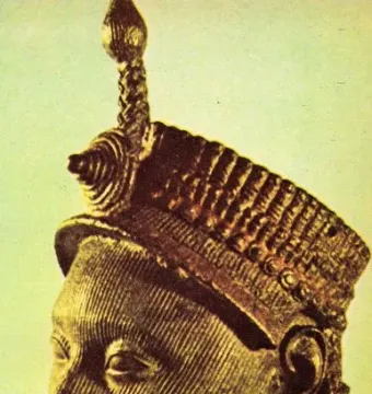 Bronze Head from Ife shown in profile, with finely detailed facial striations and an elaborate textured crown.