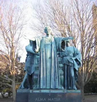 Alma Mater statue with a bronze female figure and two robed figures on a stone pedestal