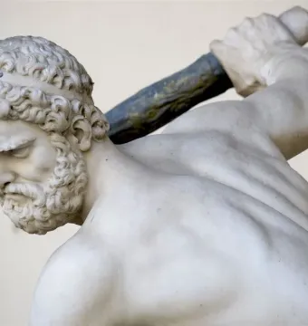 Heracles and Nessus marble sculpture showing a muscular bearded man in profile holding a club over his shoulder.