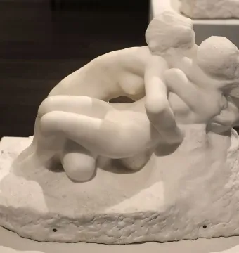 Metamorphoses, a white marble sculpture of two nude figures in an intertwined embrace.