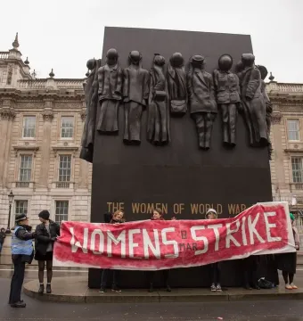 Monument to the Women of World War II with bronze figures of women in uniform and civilian clothing on a dark rectangular memorial.