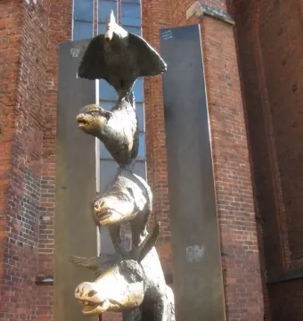 Bremer Stadtmusikanten bronze sculpture stacked in front of a brick building in Riga.