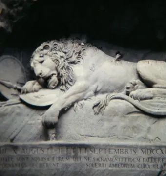 Lion Monument in Lucerne showing a dying lion carved into a rock grotto with a broken spear and shield.