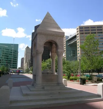 Bagley Memorial Fountain, a light-colored stone monument with arched openings and a pyramidal top in an urban plaza.