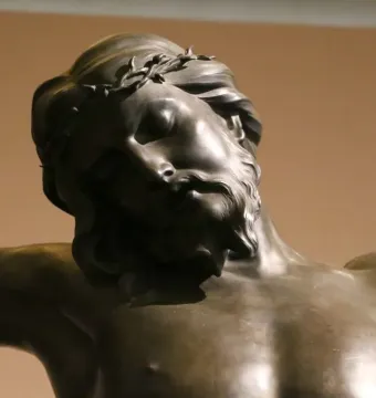 Close-up of Bernini\'s bronze Corpus showing the head and upper torso of Christ with closed eyes and a crown of thorns.