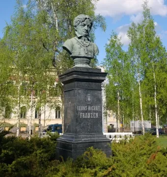 Bust of Frans Michael Franzén on a tall stone pedestal with carved lettering and a lyre emblem.