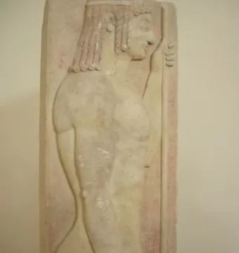 Grave stele relief of a youthful male figure in profile holding a staff against a red background.