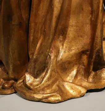 Lower part of Saint Louis of Toulouse, showing gilded draped robes, bare feet in sandals, and the decorated staff base.