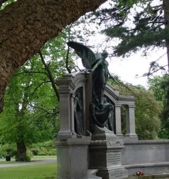 Titanic Engineers\' Memorial with a winged female figure and bronze statues in a park.