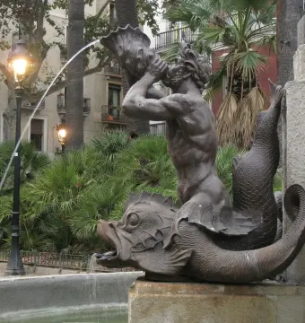 Bronze triton fountain detail from the Galceran Marquet Monument, with a merman blowing a conch shell.