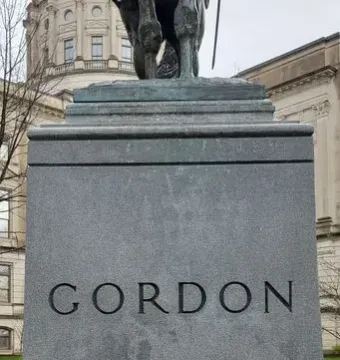 Granite pedestal for the John Brown Gordon statue with the name GORDON carved on the front and part of the bronze equestrian figure above it.