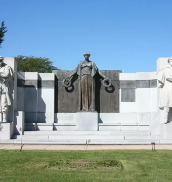 Soldiers\' Monument in Oregon, Illinois, featuring a bronze-toned draped female figure with wreaths flanked by two stone soldiers.