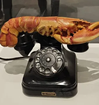 Salvador Dalí’s Lobster Telephone, showing a black rotary phone with a reddish-orange lobster on the cradle.