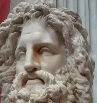 White marble bust of Zeus of Otricoli with a curly beard and voluminous hair.