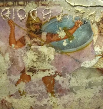 Detail of the Amazon Sarcophagus showing a bearded warrior facing a partially draped female figure on a faded painted surface.